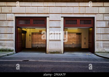 London, UK - 2 April 2021 : zwei Gebäude Auto Eingang mit Garagenaufzug ein Aufzug Eingang Stockfoto