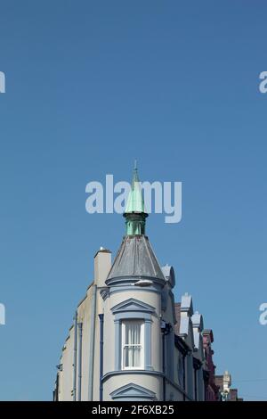 Caernarfon, Wales. Detaillierte Aufnahme des alten viktorianischen Gebäudes und seiner Dächer. Elegantes Design im neoklassizistischen Stil. Blauer Himmel Hintergrund und Kopierbereich Stockfoto