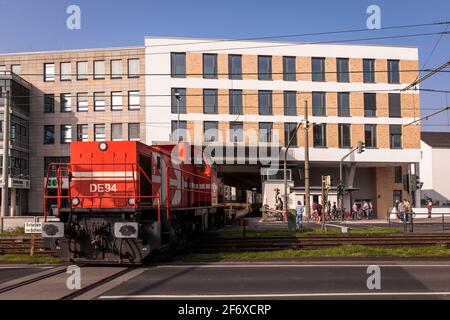 Bahnstrecke mit drei Wohngebäuden am Clarenbachplatz im Kölner Stadtteil Braunsfeld. Güterzüge bis 700 Meter Stockfoto