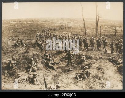 Das Bild zeigt eine Spalte deutsche Soldaten marschieren über eine von Granaten umgekippt Schlachtfeld.in der Vorhand, eine andere Gruppe machen eine Pause in den Schutz der Granatlöcher.im Hintergrund sehen Sie, wie eine große Anzahl von Soldaten auf einer breiten Front rucken .. Das Bild zeigt eine Kolonne deutscher Soldaten, die über einen von Granaten marschieren, die das Schlachtfeld verstören.in der Vorhand macht eine andere Gruppe eine Pause beim Schutz von Granatlöchern.im Hintergrund sieht man, wie sich eine große Anzahl von Soldaten auf einer breiten Front bewegt. Stockfoto