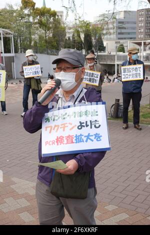 Yokohama, Japan. April 2021. Ein Protestant mit einer Maske hält während der Demonstration eine Rede, während er ein Plakat hält.Wir brauchen keine Waffen, aber Corona setzt Gegenmaßnahmen ein." Senioren zeigen ihre Meinung zu verschiedenen innenpolitischen Themen. Sie fordern unter anderem die Absage der Olympischen Spiele 2020 in Tokio, da sie die Verbreitung des Corona-Virus in Japan befürchtet. (Foto: Stanislav Kogiku/SOPA Images/Sipa USA) Quelle: SIPA USA/Alamy Live News Stockfoto