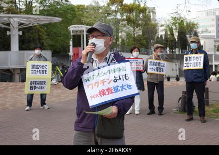 Yokohama, Japan. April 2021. Ein Protestant mit einer Maske hält während der Demonstration eine Rede, während er ein Plakat hält.Wir brauchen keine Waffen, aber Corona setzt Gegenmaßnahmen ein." Senioren zeigen ihre Meinung zu verschiedenen innenpolitischen Themen. Sie fordern unter anderem die Absage der Olympischen Spiele 2020 in Tokio, da sie die Verbreitung des Corona-Virus in Japan befürchtet. (Foto: Stanislav Kogiku/SOPA Images/Sipa USA) Quelle: SIPA USA/Alamy Live News Stockfoto
