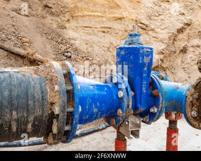 Große unterirdische Rohre und Ventile. Lange Wasserlinie bergab vom Wasserspeicher zur Stadt in der Ferne. Stockfoto