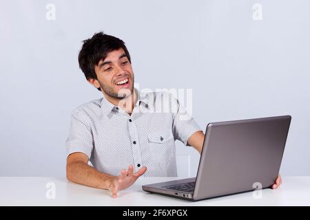 junger Mann schockiert mit etwas, das er auf seinem Laptop zu sehen Stockfoto