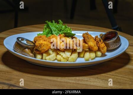 Fisch-Goujons mit Pommes frites, Ketchup und Tartarsauce Stockfoto