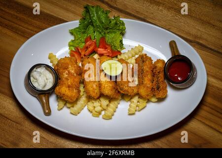 Fisch-Goujons mit Pommes frites, Ketchup und Tartarsauce Stockfoto