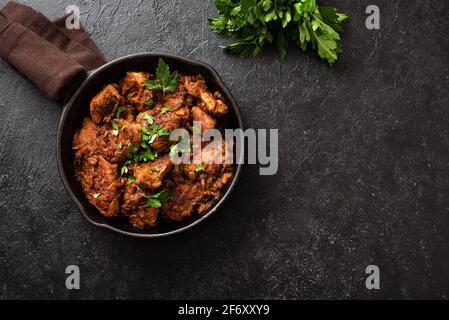 Fleischzutopf. Rindergulasch in Gemüsesauce, Draufsicht, Kopierraum. Langsam gegartes, geschmortes Fleisch in einer gusseisernen Pfanne. Stockfoto