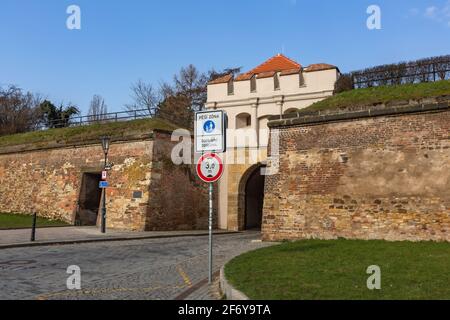 Prag, Tschechische Republik - März 26 2021: Blick auf das Tabor-Tor und eine Steinmauer, ein Teil der Festung, bei Vysehrad, Kopfsteinpflasterstraße, grüner Rasen Stockfoto