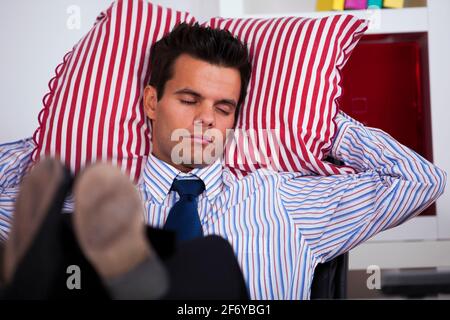 Geschäftsmann, schlafen in seinem Büro mit seinen Schuhen auf dem Tisch Stockfoto