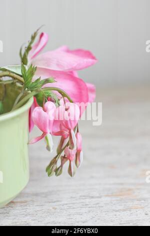 Wilde rosa Rose mit blutenden Herzen Blumen in Vintage-Tee stillleben im cup Stockfoto