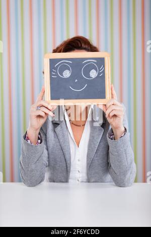 Geschäftsfrau, die sich hinter einer Tafel versteckt Stockfoto