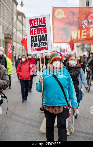 Demonstratin hält ein Schild mit der Aufschrift: ' Keine neuen Atom Raketen in Europa! Hundert Menschen sammeln sich am 3. April 2021 in München, um gegen Krieg und Aufrüstung und für eine atomwaffenfreie Welt zu demonstrieren. QUERDENKEN Gruppen hatten im Vorfeld dazu aufgerufen, den traditionellen Ostermarsch zu infiltrieren, die Veranstalter schlossen diese aber aus, so dass ohne Probleme demonstriert werden konnte. * Protestor mit Schild mit der Aufschrift: "Keine neuen Atomwaffen in Europa! Am 3 2021. April versammelten sich Hunderte in München, Deutschland, um gegen Krieg und Bewaffnung zu protestieren und Stockfoto