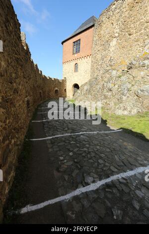 03. April 2021, Sachsen-Anhalt, Pansfelde: Weiße Markierungen am Boden geben die Entfernungsregeln für Besucher auf dem Schlossgelände an. Schloss Falkenstein im südlichen Harz wurde nach einer langen Pause aufgrund der Corona-Pandemie erstmals wieder für Besucher geöffnet. Nach telefonischer Buchung können Besucher das Schlossgelände besichtigen und eine Falknervorführung erleben. Die Burg liegt oberhalb des Selketals. Die befestigte Anlage wurde Anfang des 12. Jahrhunderts erbaut und im 15. Jahrhundert als Lehen an die adlige Asseburger Familie übergeben. Foto: Matthias Bein/dpa-Zent Stockfoto