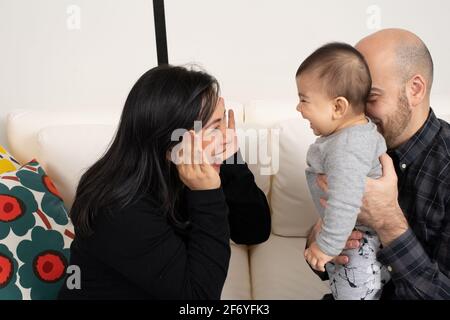 Sechs Monate alter Junge guck ein Buo-Spiel mit Mutter und Vater Stockfoto