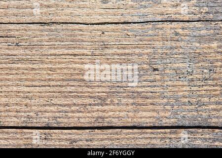 Alte sandige verwitterte, gewaschene Holzstruktur mit horizontalen Rissen und Flusssandkörnern. Natürliche strukturierte Nahaufnahme trocken Plank Hintergrund. Stockfoto