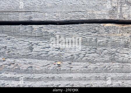 Alte sandige, verwitterte, gewaschene Holzstruktur mit horizontalen Rissringen und Körnern aus Flusssand. Natürliche strukturierte Nahaufnahme-Trockenplanke Stockfoto