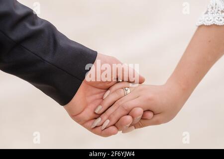 Der Bräutigam hält die Braut hand Stockfoto