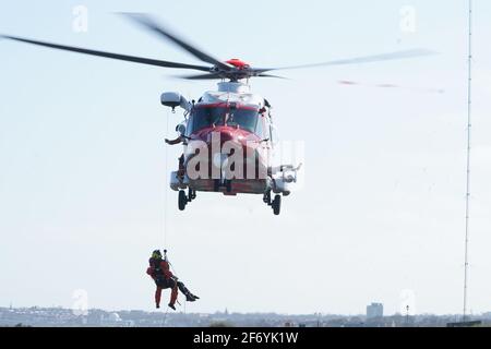 Ein Hubschrauber der Küstenwache von HM bringt eine Person in Old Hartley in der Nähe von Whitley Bay an der Küste von Northumberland in Sicherheit. Bilddatum: Samstag, 3. April 2021. Stockfoto