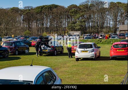 East Lothian, Schottland, Großbritannien, 3. April. 2021. UK Wetter: Sonnenschein am belebten Yellowcraig Strand. Die warme Sonne am Osterfeiertagswochenende bringt die Menschen raus, um die Natur zu genießen. Der Strandparkplatz ist an einem sonnigen Nachmittag am Osterwochenende voll mit Autos, da ein Parkwächter überprüft, ob Parkscheine gekauft wurden Stockfoto