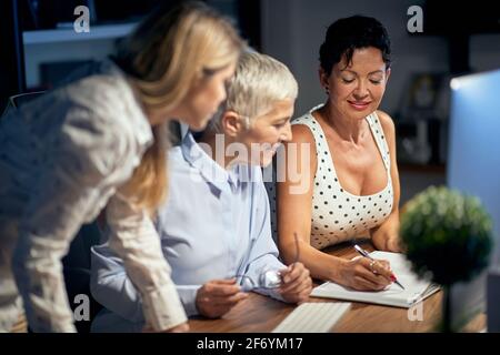 Gruppe der freudigen erfolgreichen Geschäftsfrau bei der Arbeit zusammen in Das Büro Stockfoto