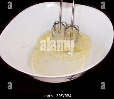 Kuchen machen: Foto, das die Bewegung eines elektrischen Schneebeckens fängt, der zum Mischen von Eiern verwendet wird. Stockfoto