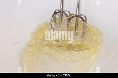 Kuchen machen: Foto, das die Bewegung eines elektrischen Schneebeckens fängt, der zum Mischen von Eiern verwendet wird. Stockfoto
