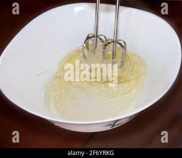 Kuchen machen: Foto, das die Bewegung eines elektrischen Schneebeckens fängt, der zum Mischen von Eiern verwendet wird. Stockfoto