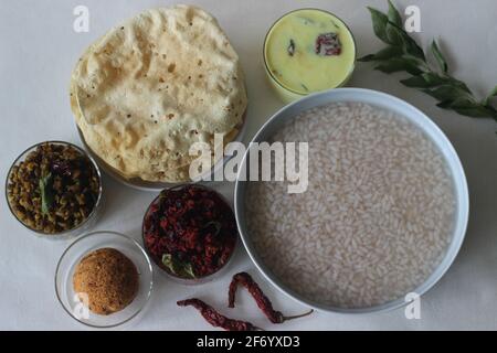 Reisbrei oder Kanji zusammen mit Kokosnuss-Chutney, Rote-Beete-Kartoffel-Thoran, gebratenem Moong, gebratenem Papad und gehärteter Buttermilch. Eine Lieblingsmahlzeit von Stockfoto