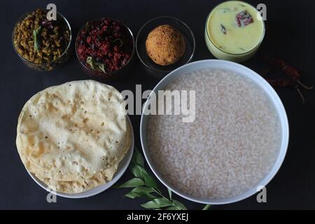 Reisbrei oder Kanji zusammen mit Kokosnuss-Chutney, Rote-Beete-Kartoffel-Thoran, gebratenem Moong, gebratenem Papad und gehärteter Buttermilch. Eine Lieblingsmahlzeit von Stockfoto