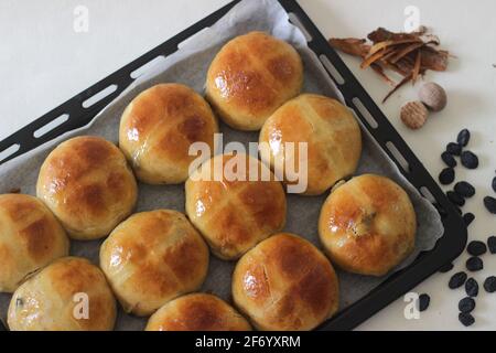 Frisch gebackene heiße Brötchen. Am Karfreitag wird ein süßes Fruchtbrötchen serviert, das leicht mit Zimt und Muskat gewürzt und mit einem Kreuz auf der Oberseite gekennzeichnet ist. A tra Stockfoto