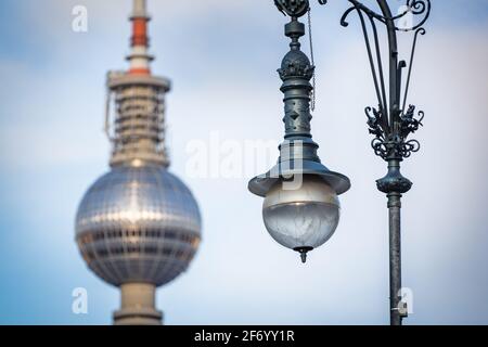 Fokussierte Straßenlampe auf der Straße mit verschwommenem fernsehturm Von berlin im Hintergrund Stockfoto