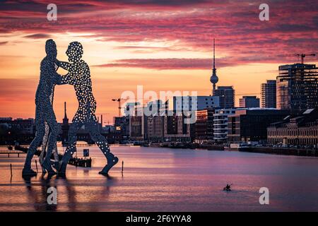 Person paddeln mit Kanu in Spree mit Statue von Molekül Mann und Blick auf den berliner fernsehturm und die oberbaumbrücke Stockfoto