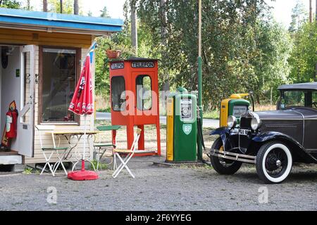 Eine alte Tankstelle mit u.a. BP-Schildern. Eine alte Telefonzelle im Hintergrund. Stockfoto