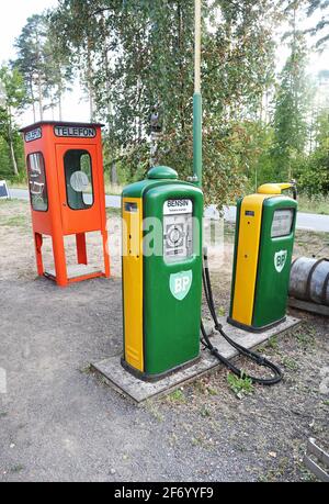 Eine alte Tankstelle mit u.a. BP-Schildern. Eine alte Telefonzelle im Hintergrund. Stockfoto