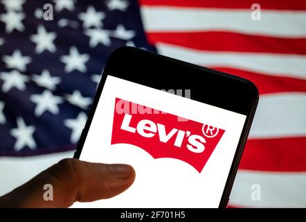 China. März 2021. In dieser Fototafel ist das Logo der amerikanischen Bekleidungsmarke Levi auf einem Smartphone mit einer Flagge der Vereinigten Staaten im Hintergrund zu sehen. (Foto: Chukrut Budrul/SOPA Images/Sipa USA) Quelle: SIPA USA/Alamy Live News Stockfoto