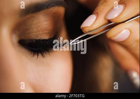 Nahaufnahme von professionellen Stylisten verlängern Wimpern für weibliche Client in einem Schönheitssalon. Stockfoto