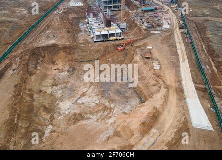 Drohnenansicht einer großen Baustelle. Schalungsgrube für den Bau eines mehrstöckigen Gebäudes oder eines Wohnhauses Stockfoto