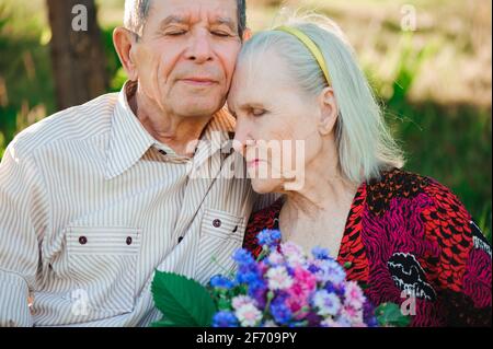 Schöne happy achtzig Jahre alte Menschen im Park sitzen. Stockfoto