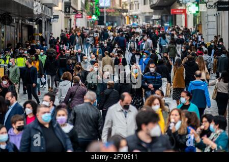 Madrid, Spanien. April 2021. Menschenmassen tragen Gesichtsmasken, um die Ausbreitung des Coronavirus zu stoppen, gehen in der Preciados Street, einem Einkaufsviertel in der Nähe des Sol-Platzes in der Innenstadt von Madrid. Die örtliche Polizei kontrolliert den Zustrom von Menschen als sanitäre Maßnahme, um Coronavirus-Infektionen während der Osterferien zu verhindern. Quelle: Marcos del Mazo/Alamy Live News Stockfoto