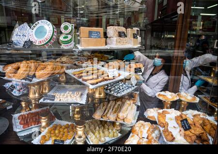 Madrid, Spanien. April 2021. Blick auf eine Konditorei mit typischen Osterbonbons wie „Torrijas“, Brotscheiben, die in Milch, Sirup oder Wein getränkt sind und nach dem Überzug mit Ei in einer Pfanne mit Öl gebraten, dann mit Honig oder Zucker gesüßt und mit Zimt gewürzt werden. Quelle: Marcos del Mazo/Alamy Live News Stockfoto