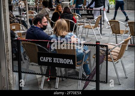 Madrid, Spanien. April 2021. Die Leute sitzen auf einer Terrasse eines Cafés in der Nähe des Sol-Platzes in der Innenstadt von Madrid. Die örtliche Polizei kontrolliert den Zustrom von Menschen als sanitäre Maßnahme, um Coronavirus-Infektionen während der Osterferien zu verhindern. Quelle: Marcos del Mazo/Alamy Live News Stockfoto