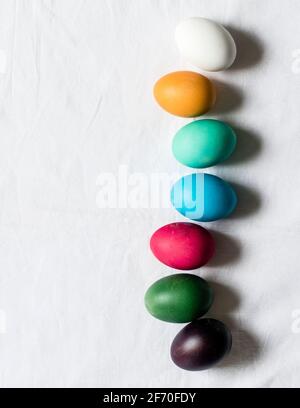 Ostern, minimalistische Szene - gefärbte Eier liegen auf einem Tisch, bereit, in den Osterkorb gelegt werden. Stockfoto