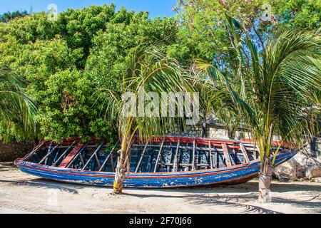 Altes rotes und orangefarbenes Boot am tropischen Strand Stockfoto