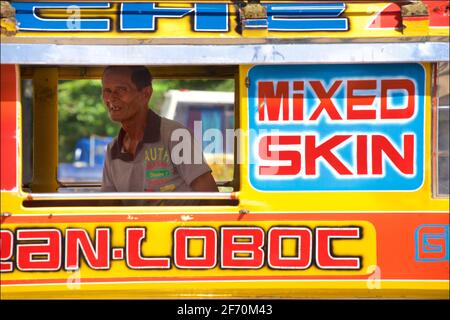 Filipino Jeeney auf Bohol Island, Central Visayas, Bohol, Philippinen. Jeepney-Dirigent in Jeepneys Fenster gerahmt. Stockfoto