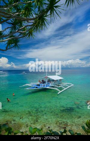 Taucherboot in den Gewässern vor Moalboal, einem beliebten Tauchresort auf der Insel Cebu auf den Philippinen. Panagsama Beach. Stockfoto