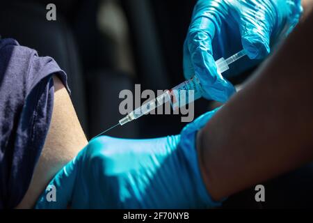 Eine Frau erhält einen Covid-19-Schuss auf einer Sutter Health-Fahrt durch die Impfstelle in Santa Cruz, Kalifornien. 3. April 2021 Stockfoto