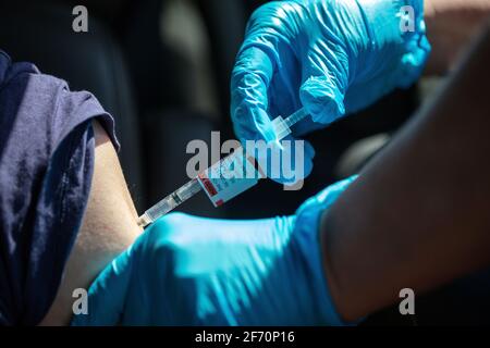 Eine Frau erhält einen Covid-19-Schuss auf einer Sutter Health-Fahrt durch die Impfstelle in Santa Cruz, Kalifornien. 3. April 2021 Stockfoto