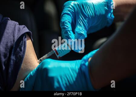 Eine Frau erhält einen Covid-19-Schuss auf einer Sutter Health-Fahrt durch die Impfstelle in Santa Cruz, Kalifornien. 3. April 2021 Stockfoto