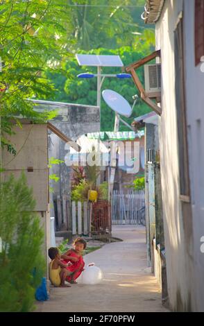 Philippinische Kinder spielen in einer engen Dorfstraße, Logon, Malapascua Island, Cebu, Philippinen. Stockfoto