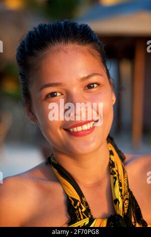 Gruppenportrait von drei jungen, attraktiven Filipinas, die in einem Strandrestaurant in Logon, Malapascua Island, Cebu, Philippinen, arbeiten. Stockfoto